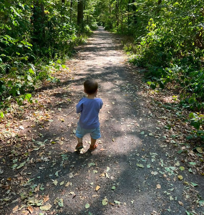 Liam läuft allein einen Waldweg entlang